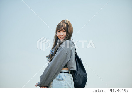 青空を背景に立つZ世代の女性 青空を背景に立つZ世代の女性 91240597