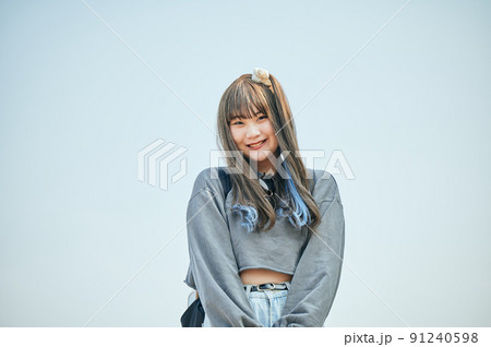 青空を背景に立つZ世代の女性 91240598