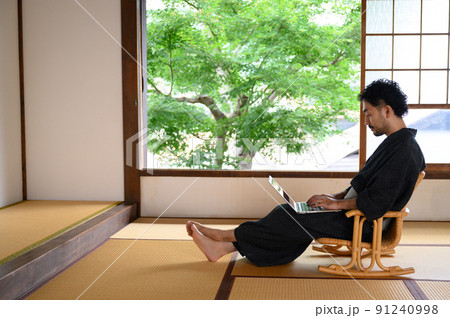 ワーケーションや休暇で旅館で仕事をする男性 91240998