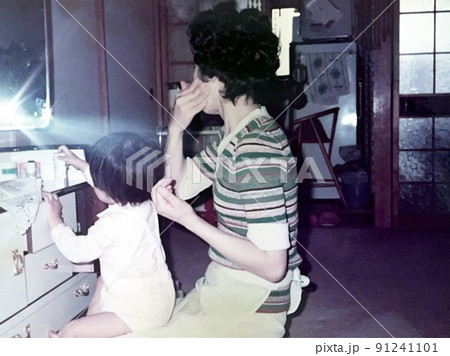 昭和50年代日本 化粧をする母親の膝に座る女の赤ちゃん 昭和50年代日本 化粧をする母親の膝に座る女の赤ちゃん 91241101