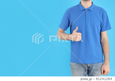 Man in blank blue polo on blue background 91241264