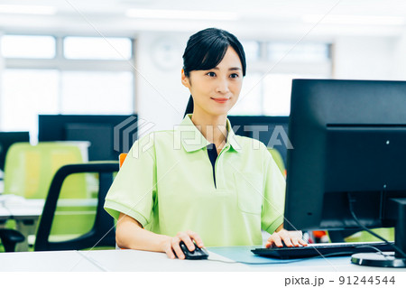 オフィスで介護事務の仕事をする若い女性 91244544