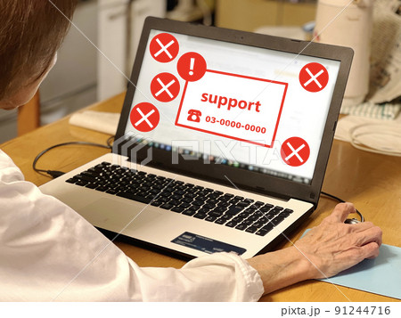 サポート詐欺画面のノートパソコンを見る高齢女性 91244716