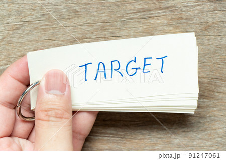Man hold the flash card with handwriting word target on wood background 91247061