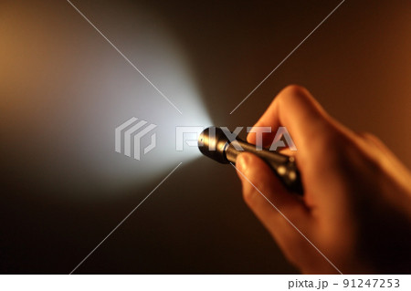 hand holding pocket flashlight hand holding pocket flashlight 91247253