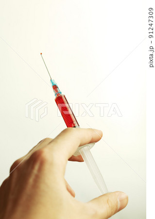 hand holding a syringe 91247309