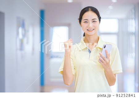 廊下でスマホを持つスタッフ　撮影協力：中央工学校附属日本語学校 91252841