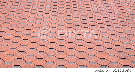 New roof with red shingles. Tiles on the roof of the house. Use to advertise roof fabrication and maintenance. Spotted texture. Affordable roofing. High quality photo with copy space. New roof with red shingles. Tiles on the roof of the house. Use to advertise roof fabrication and maintenance. Spotted texture. Affordable roofing. High quality photo with copy space. 91253039
