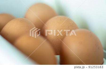 Raw chicken eggs in the refrigerator, close-up. Brown eggs in an egg rag on a shelf on the refrigerator door. selected focus. Raw chicken eggs in the refrigerator, close-up. Brown eggs in an egg rag on a shelf on the refrigerator door. selected focus. 91253163