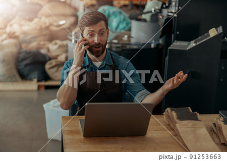 Business owner talking with client while sit on own small coffee factory 91253663