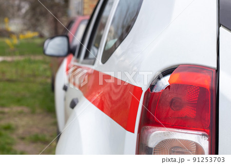 The rear left lamp of a white car is broken. The taillight of the car was shattered in the accident. Damage accident. Security concept. Rear stop of a car in an accident close-up. 91253703