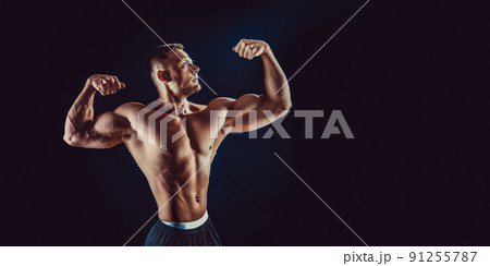 bodybuilder posing. Beautiful sporty guy male power. Fitness muscular body. Isolated on black background 91255787