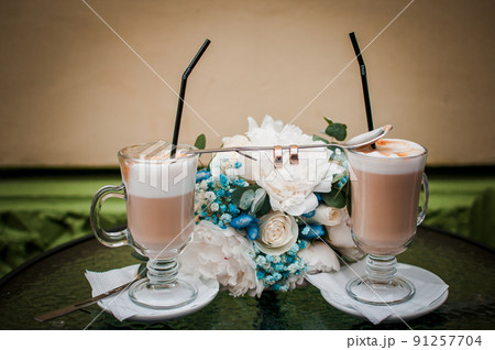 Latte spoon and wedding rings on the table Latte spoon and wedding rings on the table 91257704