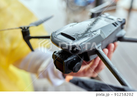 New drone a well - known company is standing on a concrete surface. Parts of a new modern quadcopter in close-up. 91258202