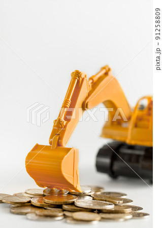 The yellow little excavator collects coins into a bunch of gold coins, business financing and banking concepts. The yellow little excavator collects coins into a bunch of gold coins, business financing and banking concepts. 91258809