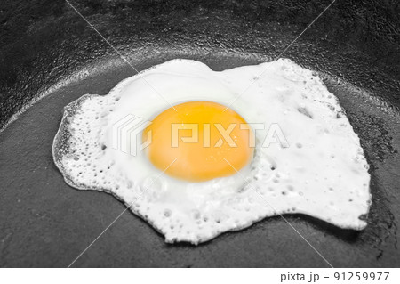 scrambled eggs in a cast iron skillet. Isolated on dark painted wood from above. scrambled eggs in a cast iron skillet. Isolated on dark painted wood from above. 91259977