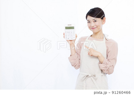 笑顔で電卓を持つ30代の主婦 笑顔で電卓を持つ30代の主婦 91260466