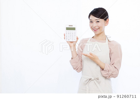 笑顔で電卓を持つ30代の主婦 91260711