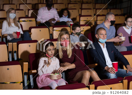 caucasian family sitting at premiere in cinema during pandemic 91264082