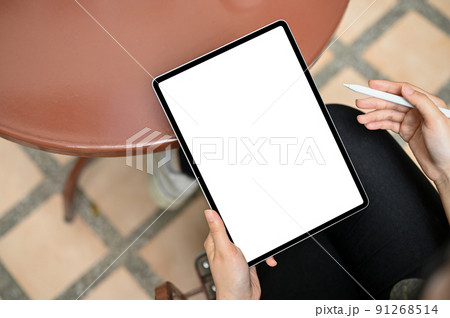 A female sitting in the garden using a digital tablet touchpad. Tablet white screen mockup. 91268514