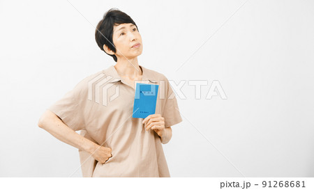 年金手帳を持ちながら不安な表情をするミドル女性	 91268681