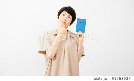 年金手帳を持ちながら不安な表情をするミドル女性 年金手帳を持ちながら不安な表情をするミドル女性 91268687
