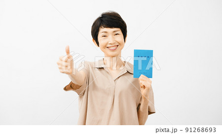 年金手帳を持ってサムズアップをするミドル女性 年金手帳を持ってサムズアップをするミドル女性 91268693