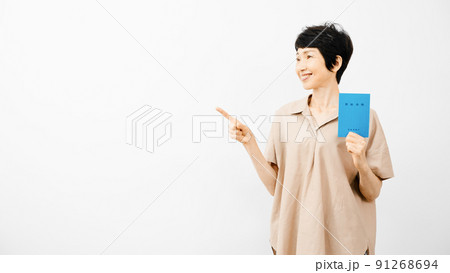 年金手帳を持って指差しをするミドル女性 年金手帳を持って指差しをするミドル女性 91268694