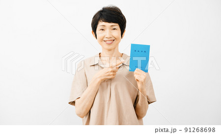 年金手帳を持って指差しをするミドル女性 年金手帳を持って指差しをするミドル女性 91268698