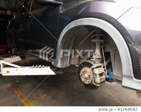 Lift is lifting a black car, removing the wheels, a car suspension repair concept. tire change 91269092