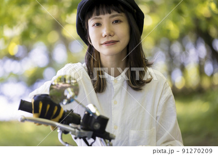 バイク女子イメージ　森でバイクにまたがる若い女性 91270209