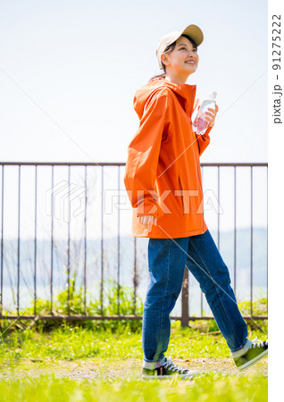 晴れた日差しの中、水分補給用のペットボトルを持って歩く若くてかわいい女性 晴れた日差しの中、水分補給用のペットボトルを持って歩く若くてかわいい女性 91275222