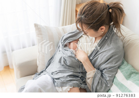授乳ケープを使って授乳する女性 91276383