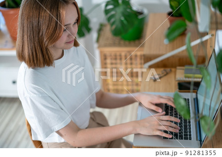 Young woman working on laptop from home. Young woman working on laptop from home. 91281355