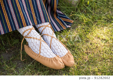 Leather bast shoes of a Latvian woman in traditional clothing. Preparing Ligo festival. Riga. Latvia 91282602