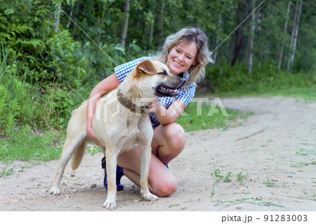 Beautiful yong woman is cuddling dog expressing animal love Beautiful yong woman is cuddling dog expressing animal love 91283003