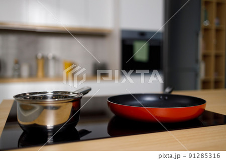 Empty frying pan and sauce pan on induction cooktop Empty frying pan and sauce pan on induction cooktop 91285316