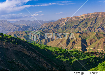 mountain landscape, a huge canyon with an abandoned farm Kurib on one of the ledges, view towards Gunib and the plateau of Gunib mountain landscape, a huge canyon with an abandoned farm Kurib on one of the ledges, view towards Gunib and the plateau of Gunib 91289498