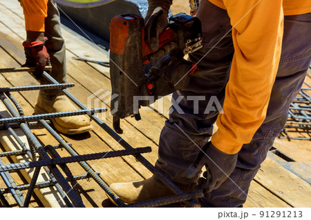 Tool used by construction workers to tie steel bars with wire rods for cement foundations 91291213