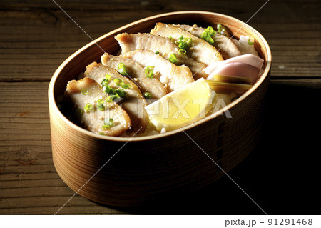曲げわっぱに漬物とカットレモンと豚トロが入っている焼肉弁当 曲げわっぱに漬物とカットレモンと豚トロが入っている焼肉弁当 91291468