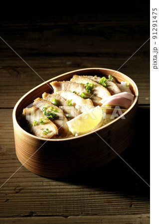 曲げわっぱに漬物とカットレモンと豚トロが入っている焼肉弁当 曲げわっぱに漬物とカットレモンと豚トロが入っている焼肉弁当 91291475