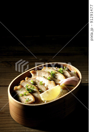 曲げわっぱに漬物とカットレモンと豚トロが入っている焼肉弁当 曲げわっぱに漬物とカットレモンと豚トロが入っている焼肉弁当 91291477