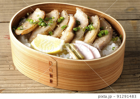 曲げわっぱに漬物とカットレモンと豚トロが入っている焼肉弁当 曲げわっぱに漬物とカットレモンと豚トロが入っている焼肉弁当 91291483