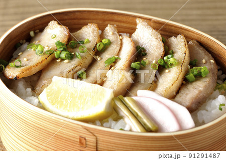 曲げわっぱに漬物とカットレモンと豚トロが入っている焼肉弁当 曲げわっぱに漬物とカットレモンと豚トロが入っている焼肉弁当 91291487