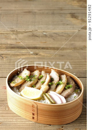 曲げわっぱに漬物とカットレモンと豚トロが入っている焼肉弁当 曲げわっぱに漬物とカットレモンと豚トロが入っている焼肉弁当 91291492