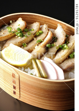 曲げわっぱに漬物とカットレモンと豚トロが入っている焼肉弁当を黒背景で撮影 曲げわっぱに漬物とカットレモンと豚トロが入っている焼肉弁当を黒背景で撮影 91291784