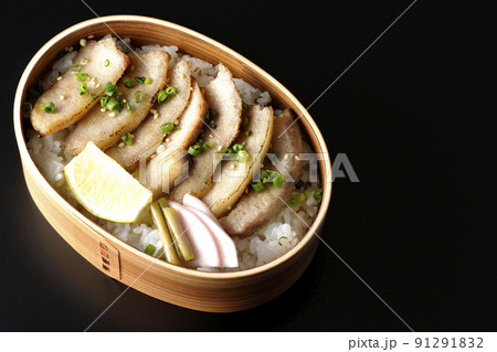 曲げわっぱに漬物とカットレモンと豚トロが入っている焼肉弁当を黒背景で俯瞰撮影 曲げわっぱに漬物とカットレモンと豚トロが入っている焼肉弁当を黒背景で俯瞰撮影 91291832