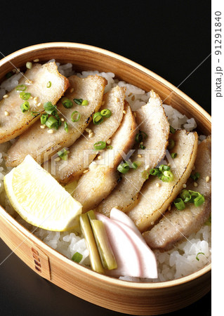 曲げわっぱに漬物とカットレモンと豚トロが入っている焼肉弁当を黒背景で俯瞰撮影 曲げわっぱに漬物とカットレモンと豚トロが入っている焼肉弁当を黒背景で俯瞰撮影 91291840