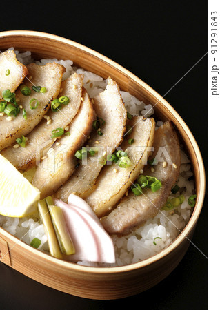 曲げわっぱに漬物とカットレモンと豚トロが入っている焼肉弁当を黒背景で俯瞰撮影 曲げわっぱに漬物とカットレモンと豚トロが入っている焼肉弁当を黒背景で俯瞰撮影 91291843