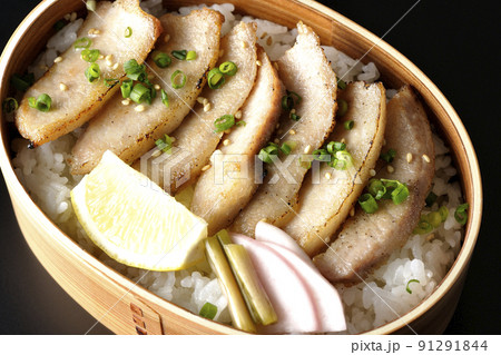 曲げわっぱに漬物とカットレモンと豚トロが入っている焼肉弁当を黒背景で俯瞰撮影 曲げわっぱに漬物とカットレモンと豚トロが入っている焼肉弁当を黒背景で俯瞰撮影 91291844